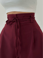 Maroon high-waisted pants with tie waist detail close-up