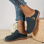 Navy perforated clogs with gold buckle angled view
