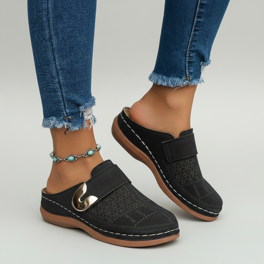 Black perforated clogs with gold buckle side view
