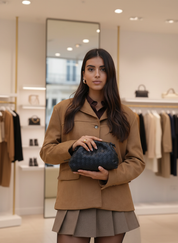 Model holding black woven clutch front view