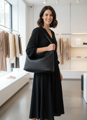 Model holding black woven hobo bag front view