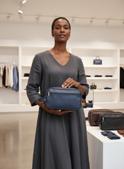 Woman holding navy blue textured toiletry bag front view