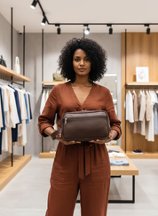 Woman holding brown textured toiletry bag front view