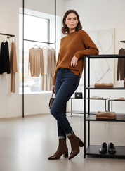 Orange sweater with blue jeans and brown boots side profile