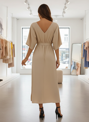 Beige maxi dress with V-neck and side slit, back view in store