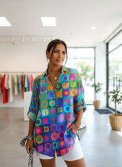 Women's bright geometric print shirt with rolled sleeves, front view.