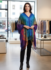 Woman wearing colorful peacock print scarf draped over shoulders, full body view