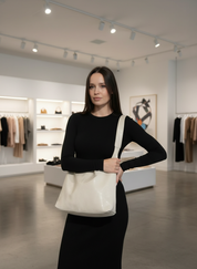 White leather shoulder bag worn by model in store