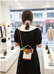 Handbag with silk scarf beige and brown worn on shoulder in store