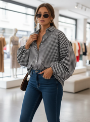 Woman adjusting black and white checkered shirt, side view