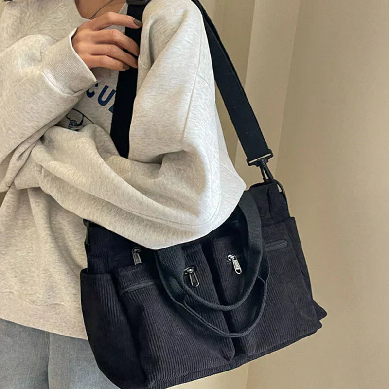 Dark blue corduroy shoulder bag with multiple pockets, front view