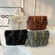 Four corduroy shoulder bags in dark blue, cream, brown, and green, arranged in a row