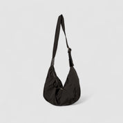 Black shoulder bag with adjustable strap, side view