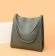 Gray tote bag with textured leather angled view