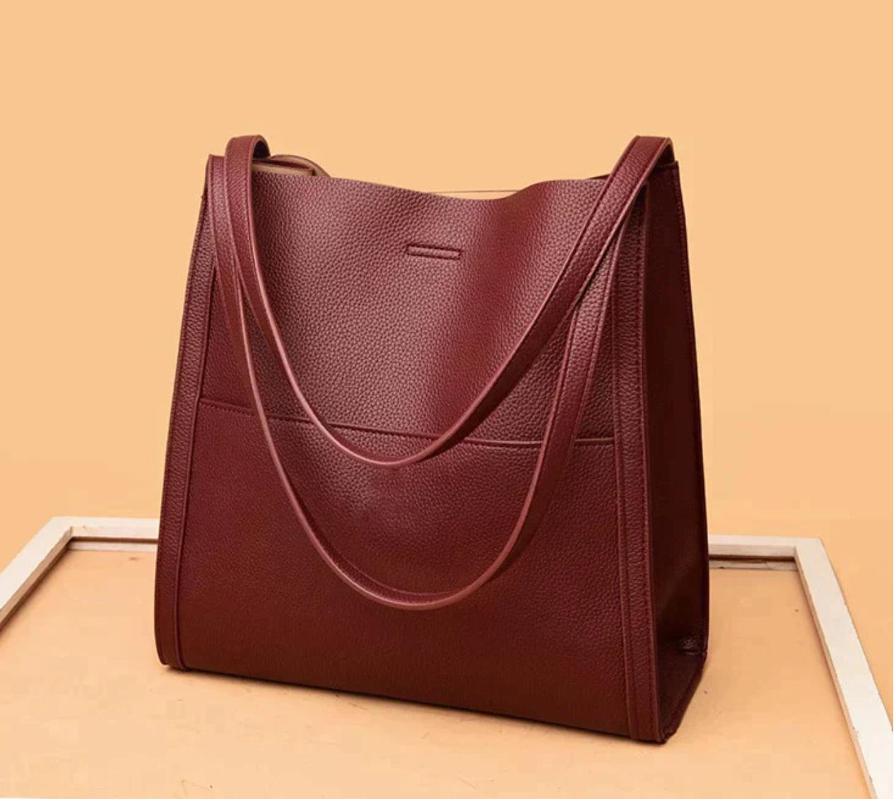 Red tote bag with textured leather angled view
