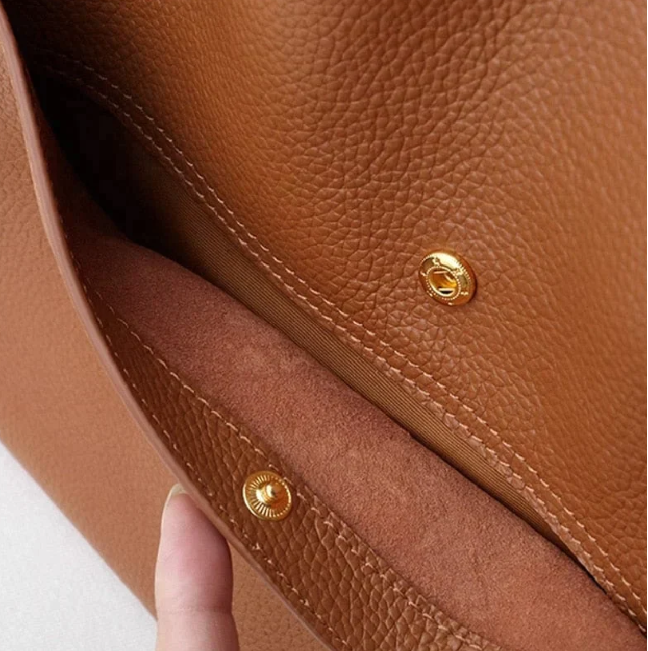 Gold hardware detail on brown tote bag textured leather