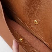 Gold hardware detail on brown tote bag textured leather