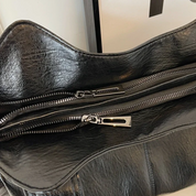 Schoudertas zwart leer detail shot rits met zilveren trekker