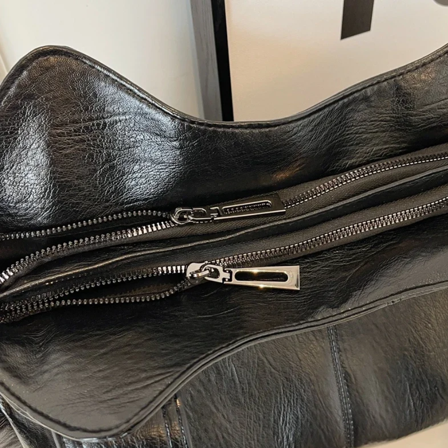Schoudertas zwart leer detail shot rits met zilveren trekker