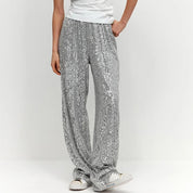 Silver sequin pants with white t-shirt and sneakers, close-up detail