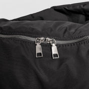 Black shoulder bag zipper with metal pullers, close-up detail