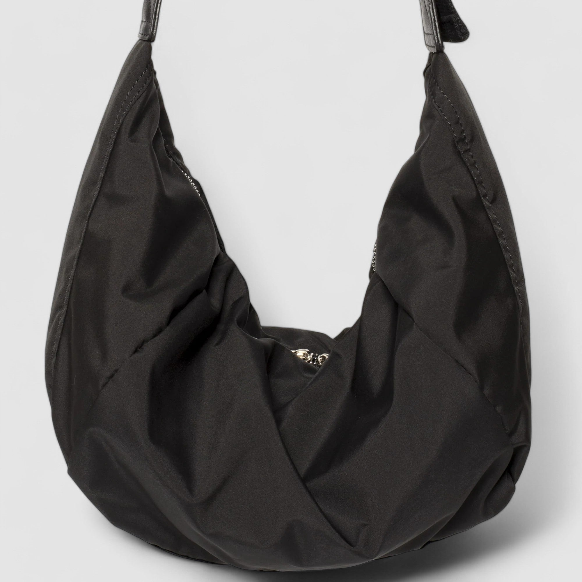 Black shoulder bag with adjustable strap, close-up front view