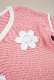 Rosa trui met witte bloemdetail en overdunde schouders close-up