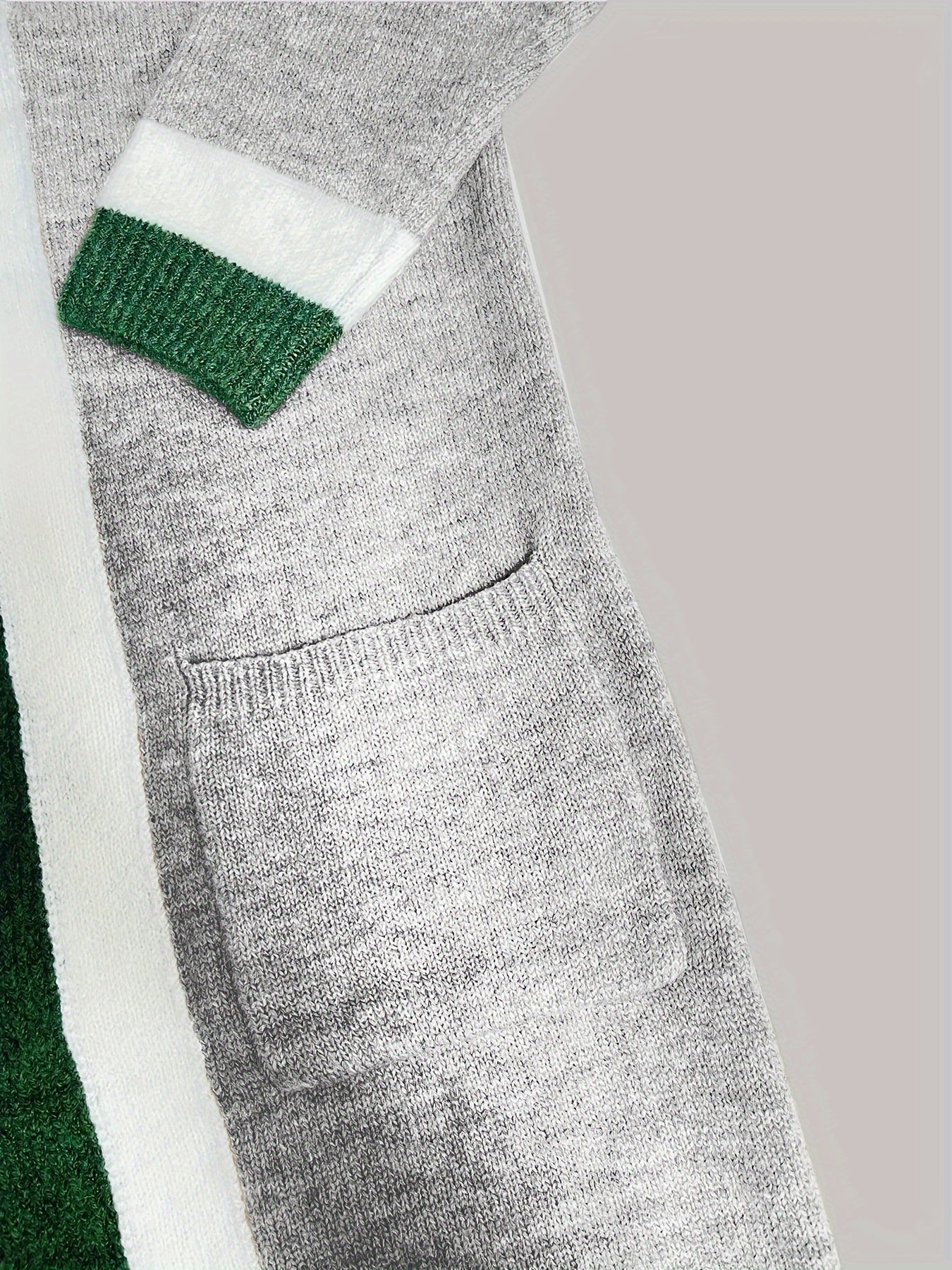Open trui met colorblock design, grijze stof met groene en witte details, detail shot
