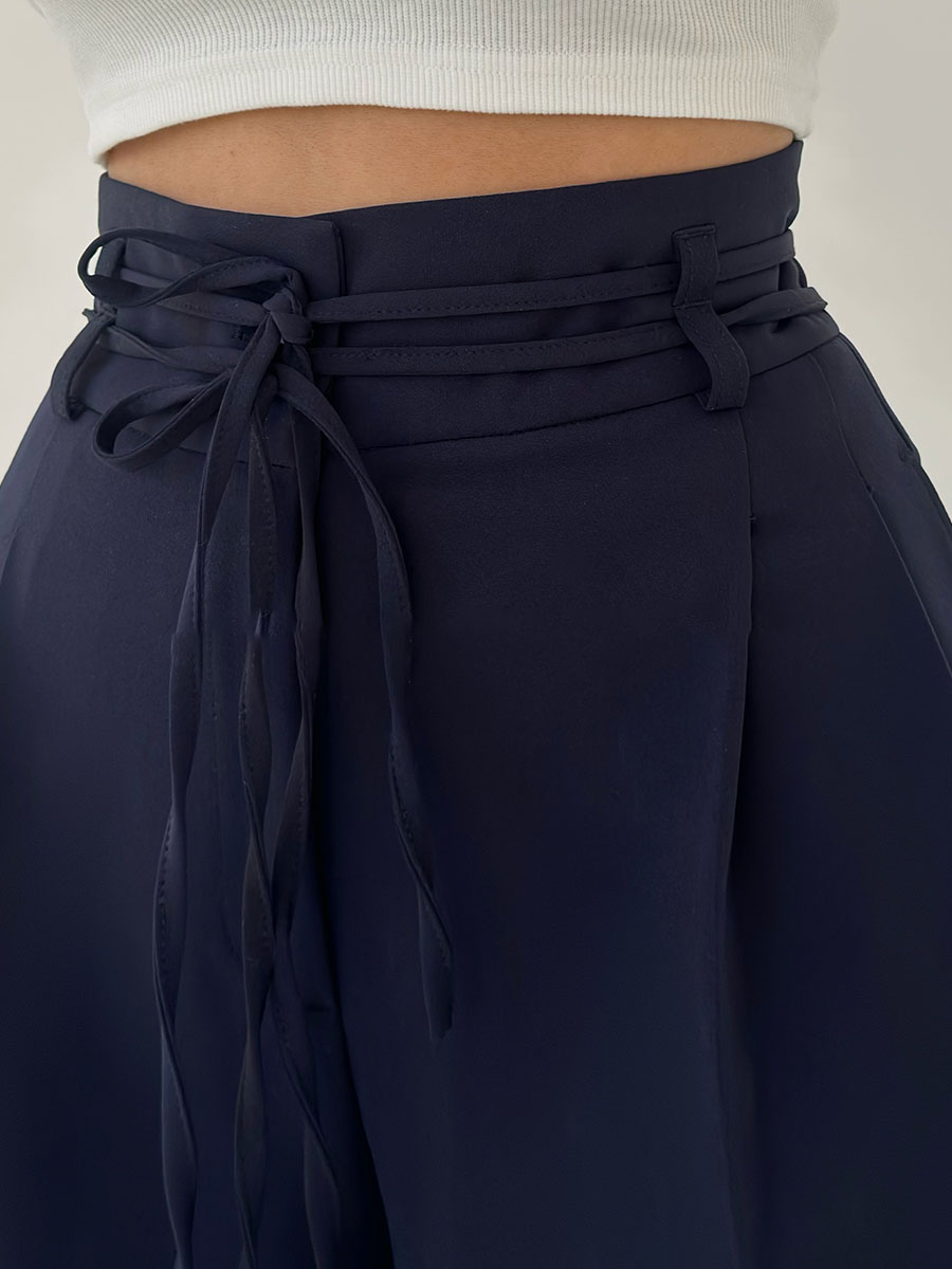Navy high-waisted pants with tie waist detail close-up