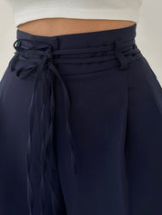 Navy high-waisted pants with tie waist detail close-up