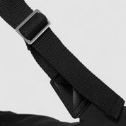 Black shoulder bag strap with metal buckle, close-up detail
