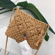 Beige macramé crossbody bag held by hand