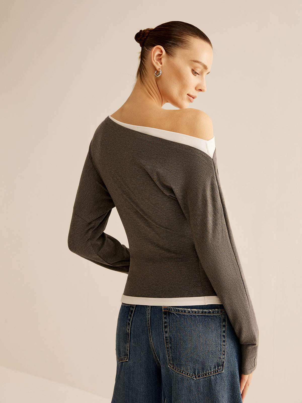 Dames trui asymmetrisch design donkergrijs met wit contrastzomen zijprofiel