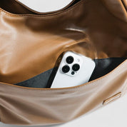 Tan leather slouchy shoulder bag with phone inside