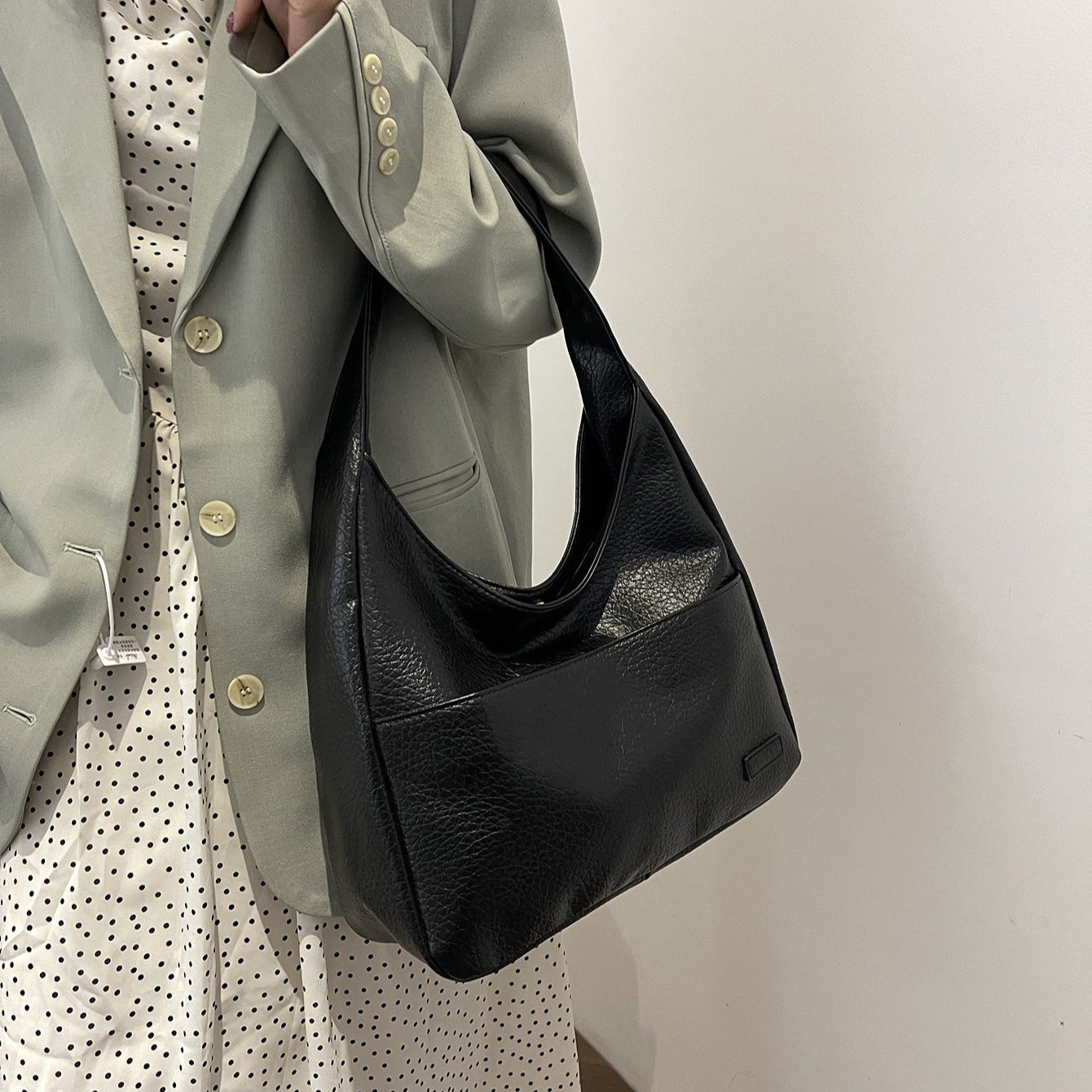Black leather hobo bag worn over shoulder