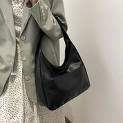 Black leather hobo bag worn over shoulder