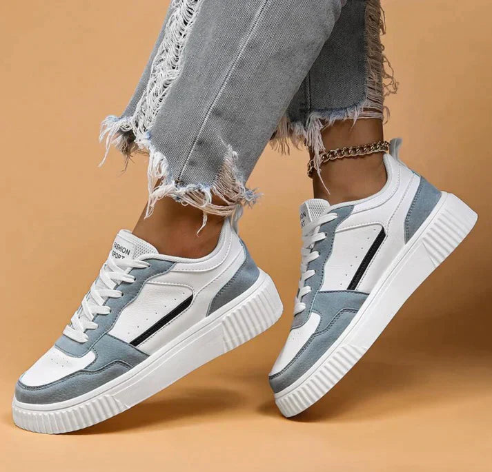 White and light blue sneakers with platform sole, angled view