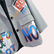 Close-up of blazer with colorful text patches and buttons