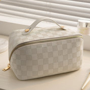 Make-up tas wit met ruitpatroon en gouden details, bovenaanzicht
