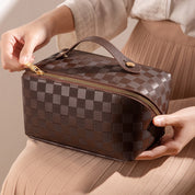 Make-up tas bruin met ruitpatroon, handvat en rits, detail shot