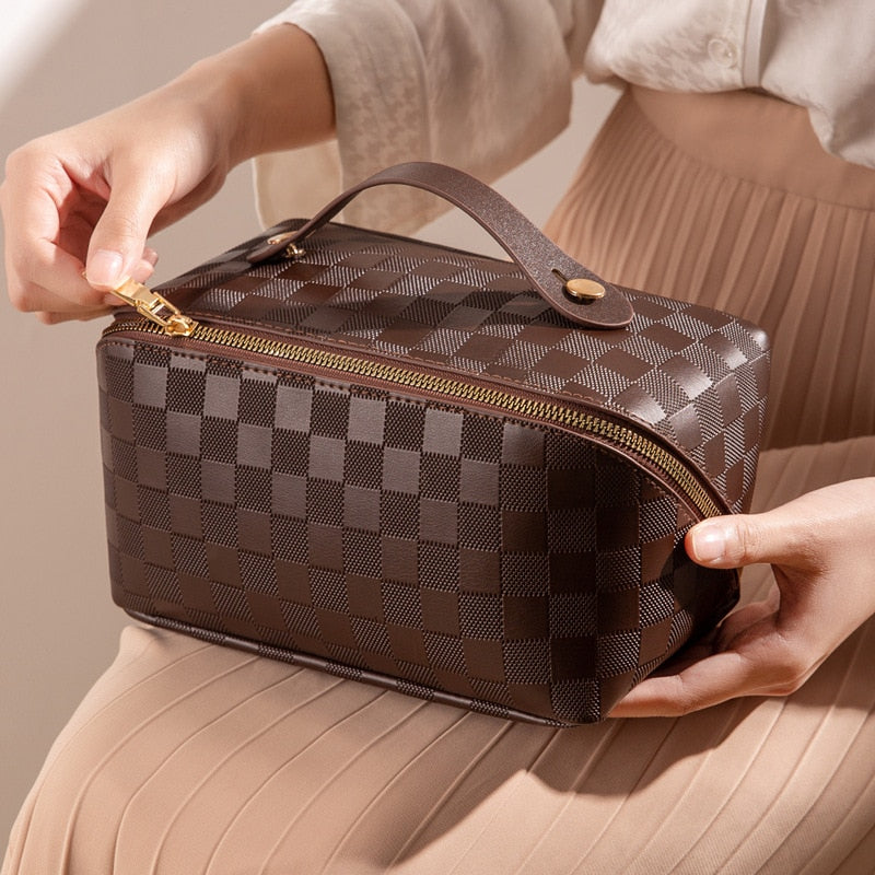 Make-up tas bruin met ruitpatroon, handvat en rits, detail shot