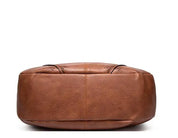Brown leather hobo bag bottom view with perforated details