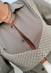 Pearl bralette white worn with gray blazer, close-up on chest