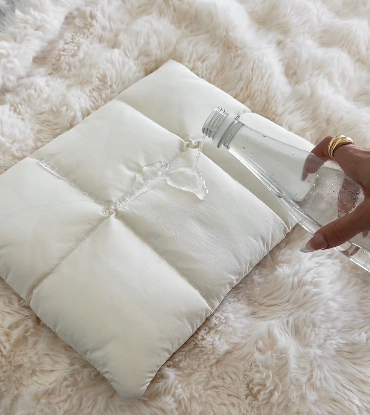 Witte puffer laptophoes op zachte deken detailopname