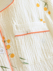 Pyjama set wit met gele bloemen en oranje details detail shot
