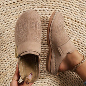 Beige perforated clogs with gold buckle interior detail