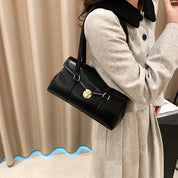 Black vegan leather shoulder bag worn with coat
