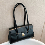 Black vegan leather shoulder bag on white surface