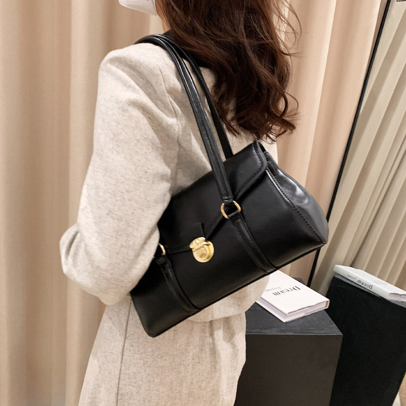 Black vegan leather shoulder bag worn by model