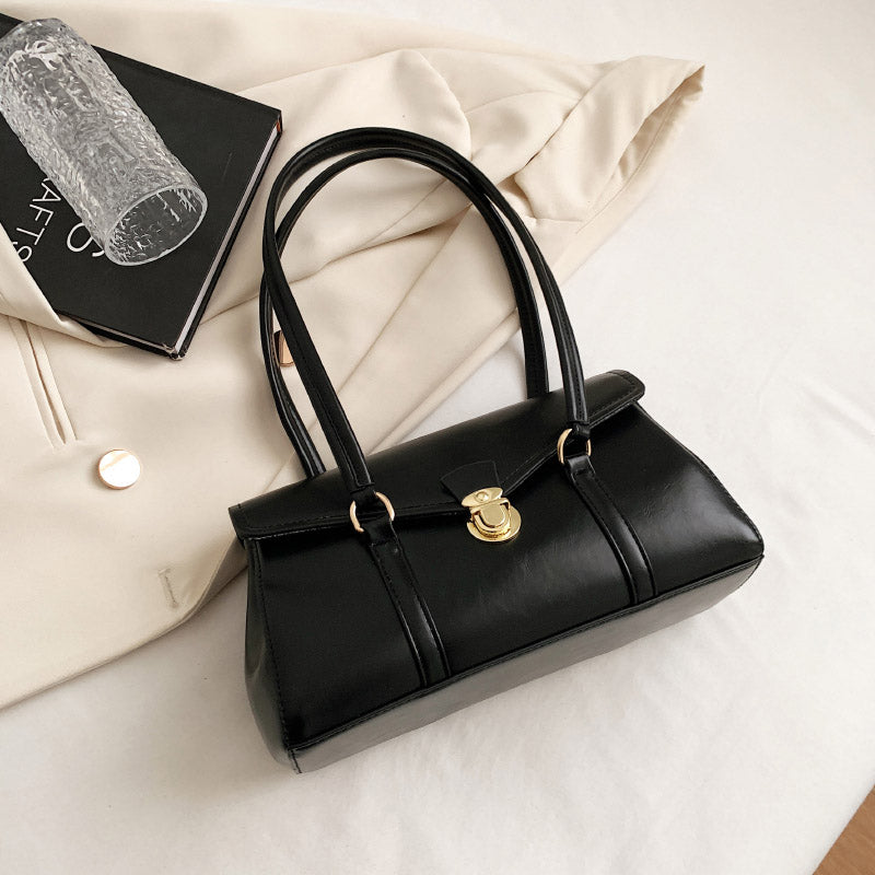 Black, brown, and beige vegan leather shoulder bags on white background